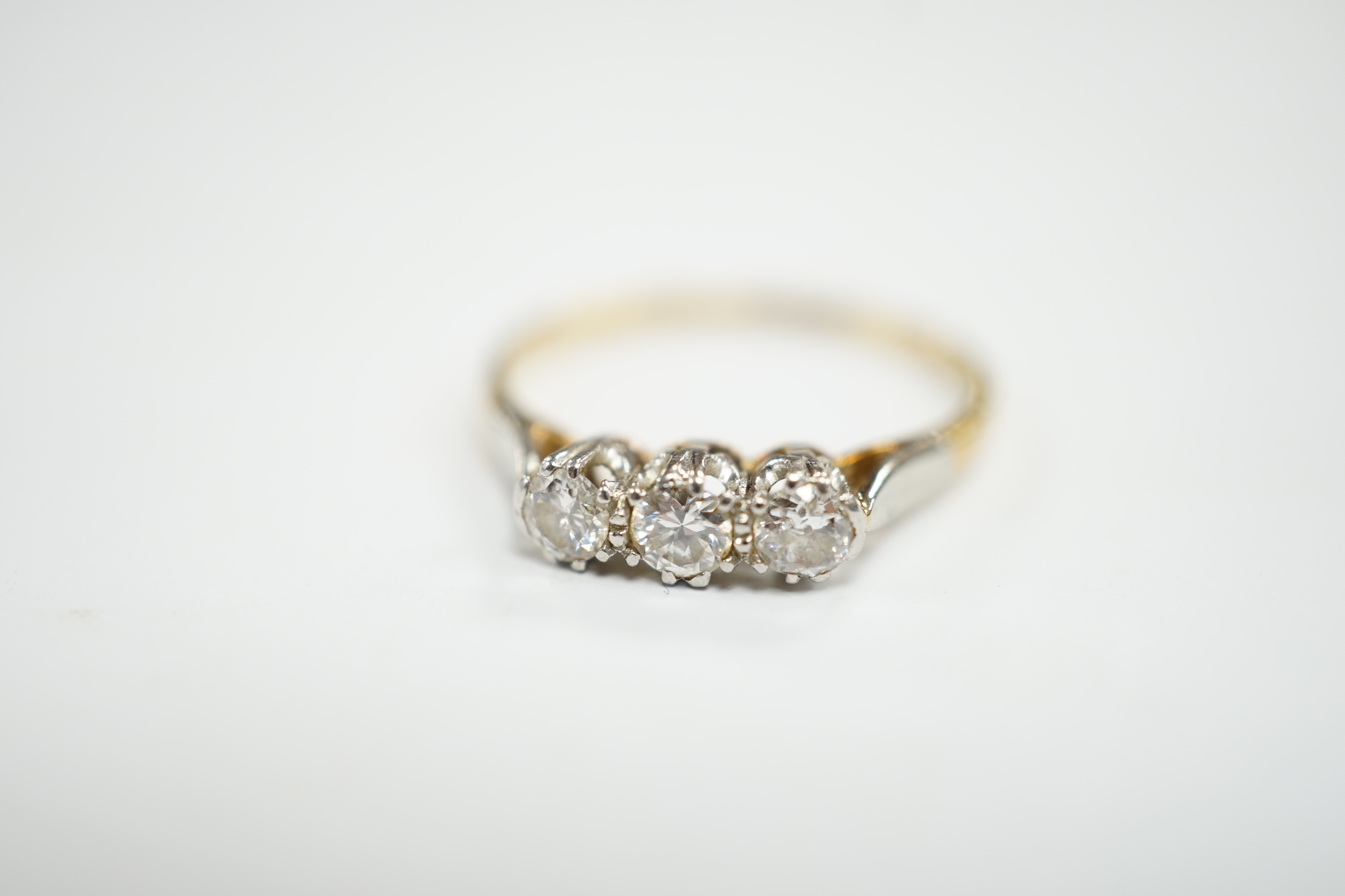 An 18ct, plat and three stone diamond set ring, size P/Q, size 2.6 grams.